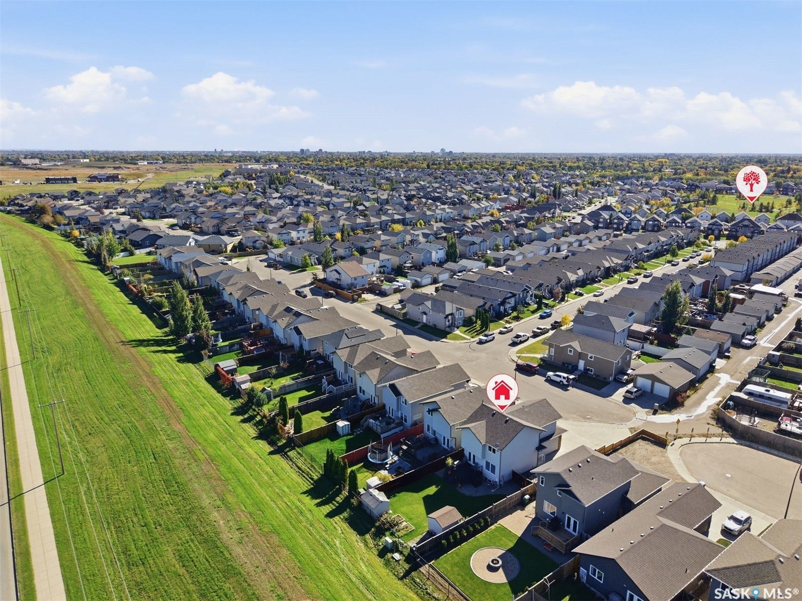 Expansive residential neighborhood with numerous detached homes, paved streets, and a prominent greenbelt bordering the property