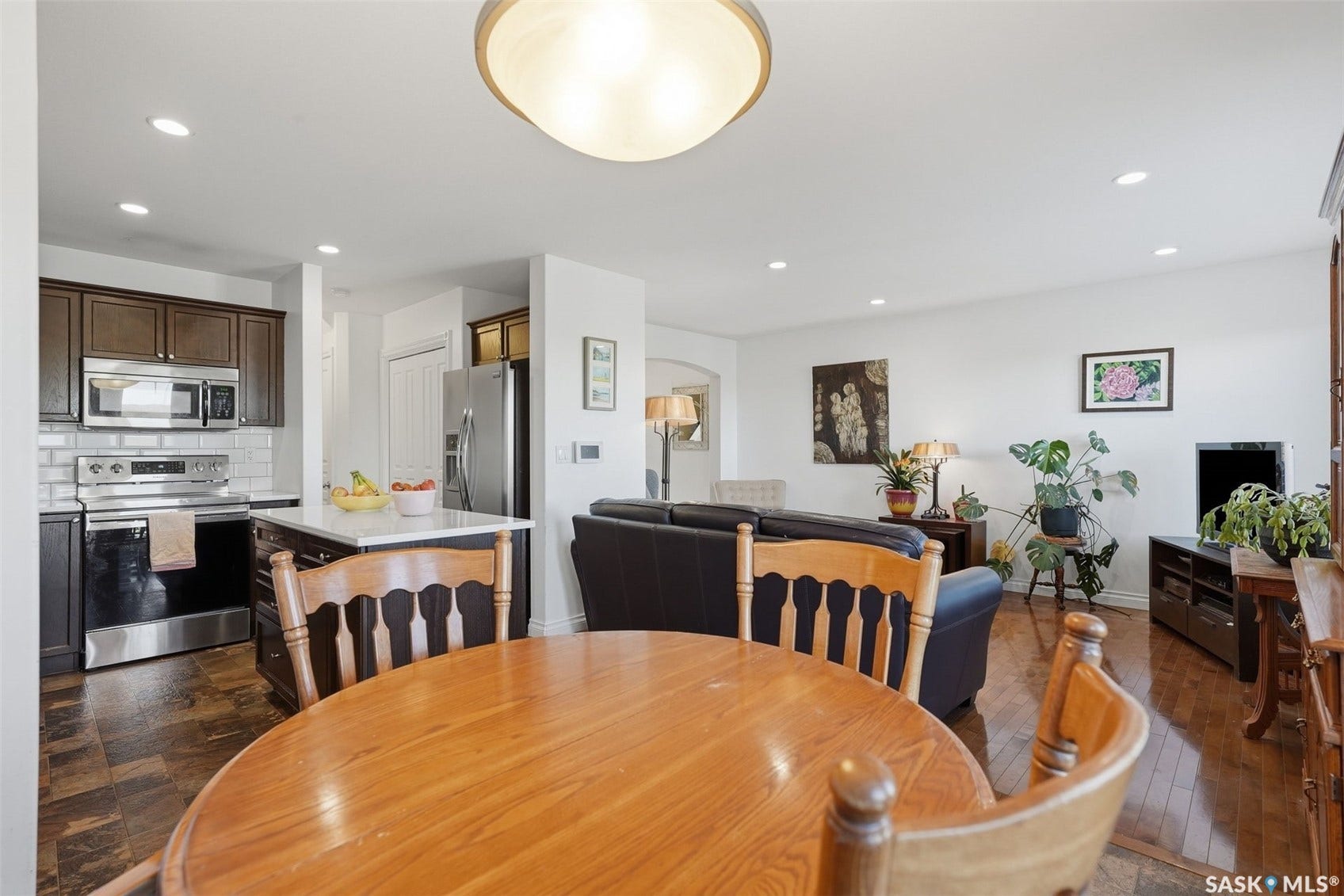 Kitchen with dark wood cabinetry, stainless steel appliances, and a white subway tile backsplash