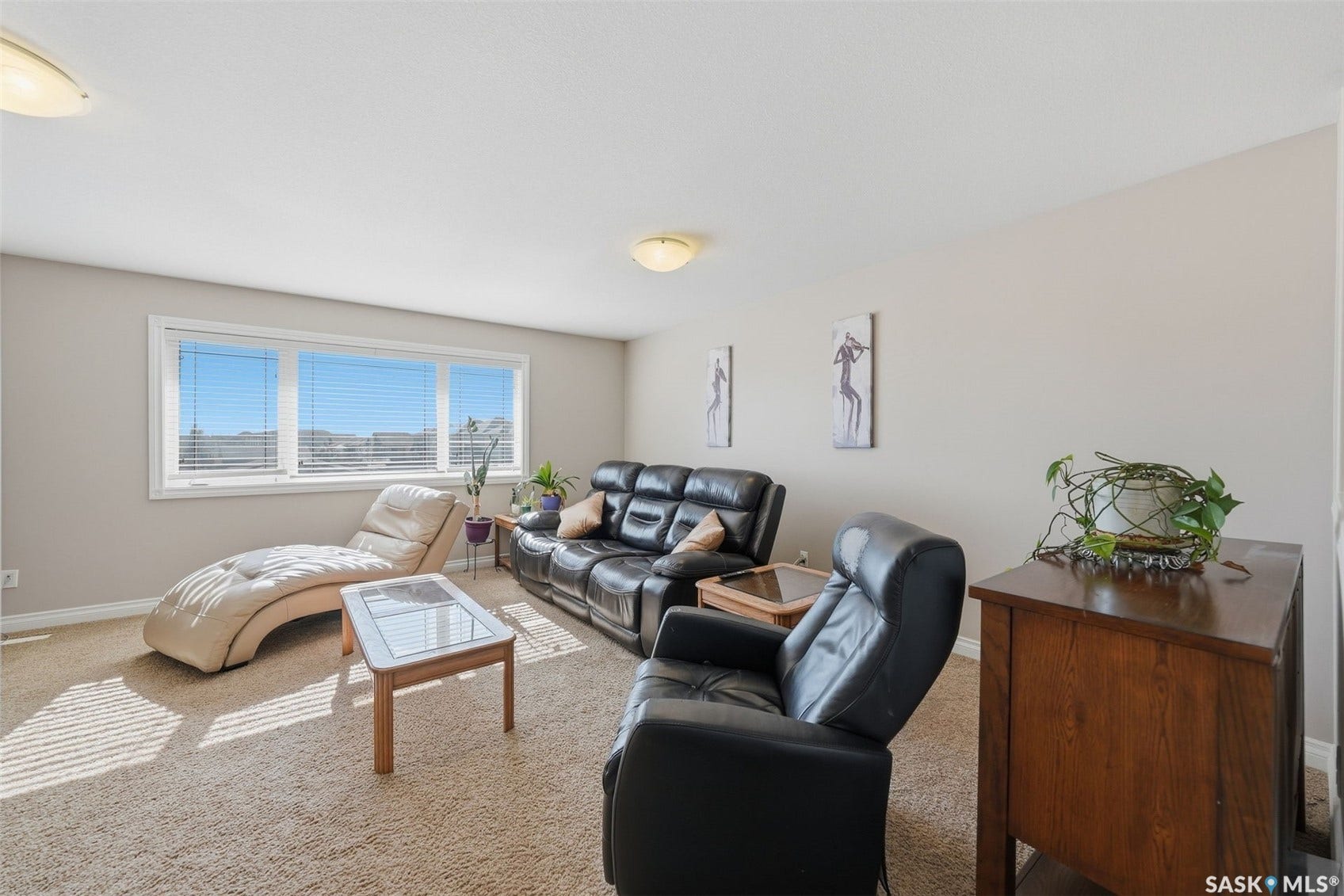 Carpeted flooring, expansive windows with blinds, and white painted walls