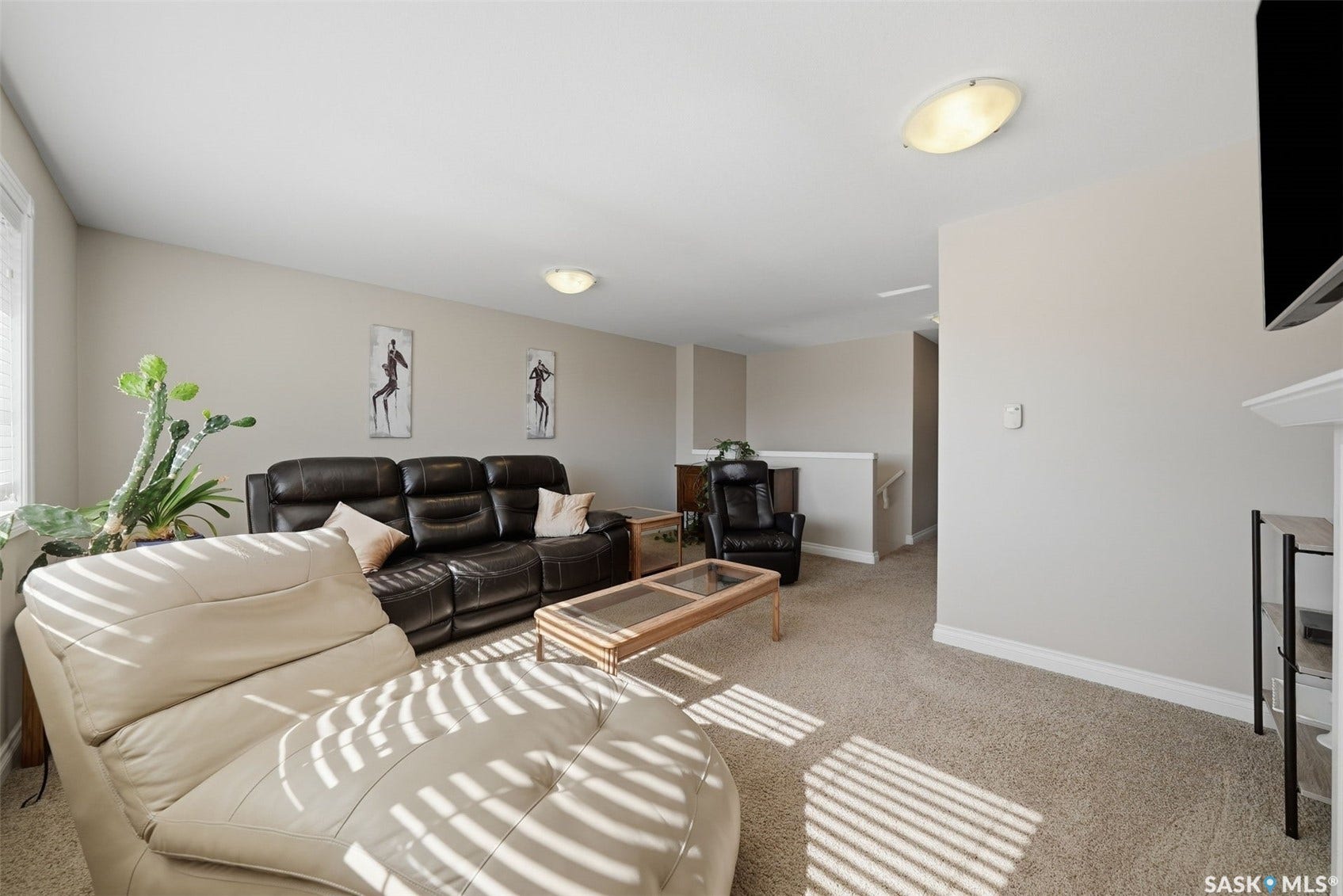 Neutral wall paint, plush carpet flooring, recessed ceiling lights, white trim, and a white railing