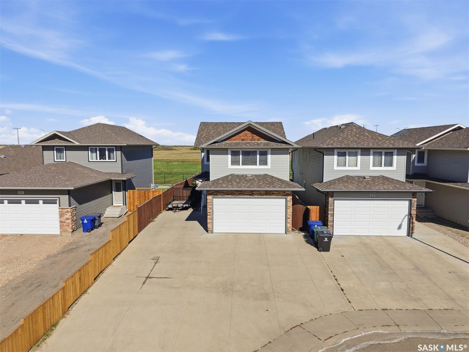 Two-story residence with a two-car garage, concrete driveway, and light gray siding