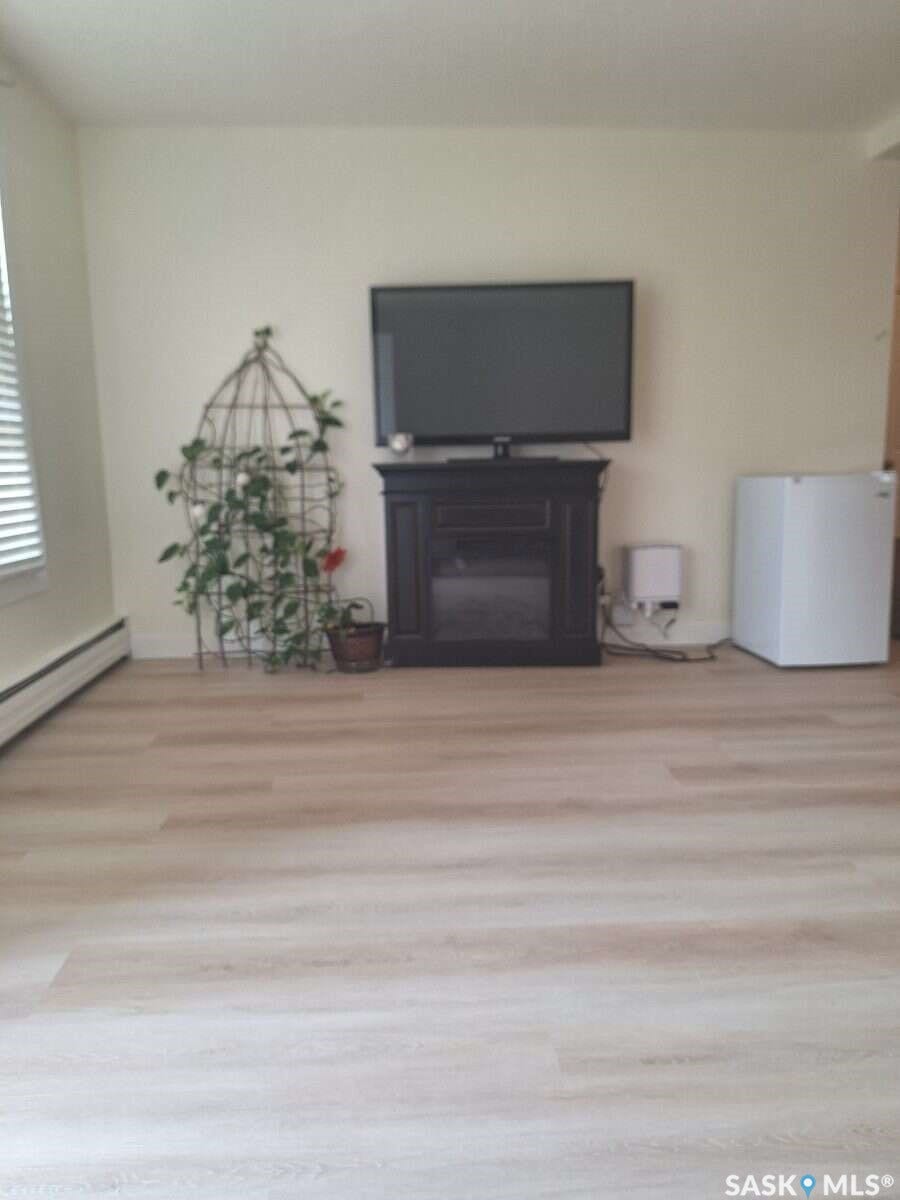 Light-toned wood-finish flooring complements the neutral wall color