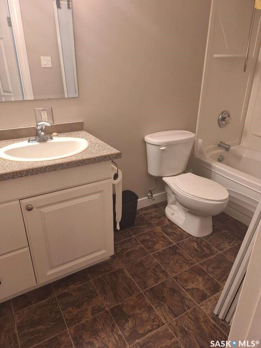 White vanity with an integrated sink and speckled countertop