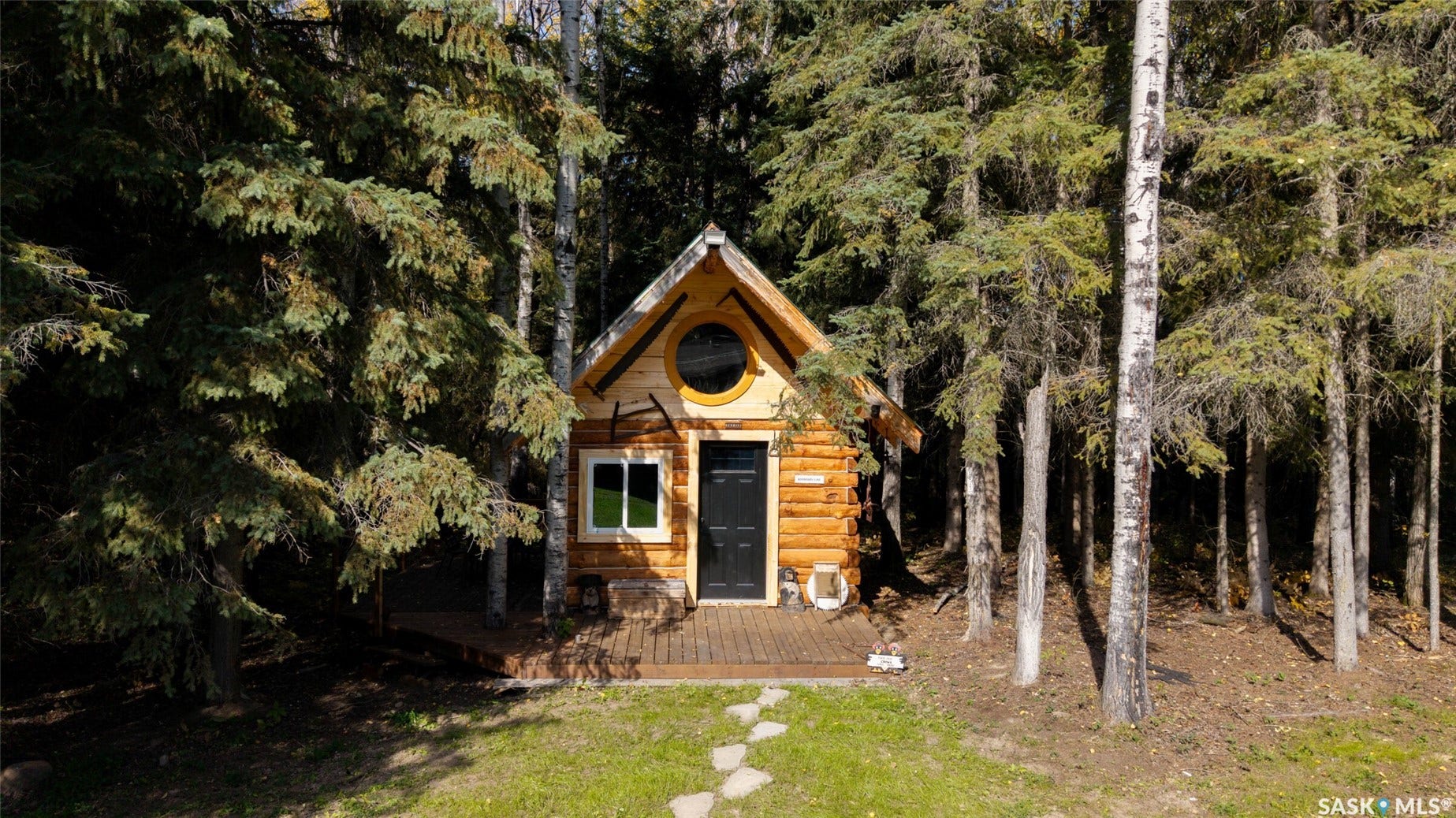 Wood-finish exterior featuring a gabled roof and a circular window