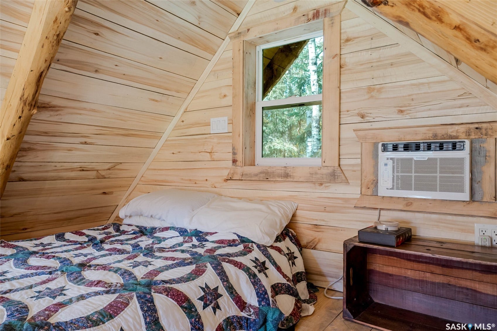 Wood-paneled interior with exposed wood beams, fixed window, and wall-mounted air conditioning unit