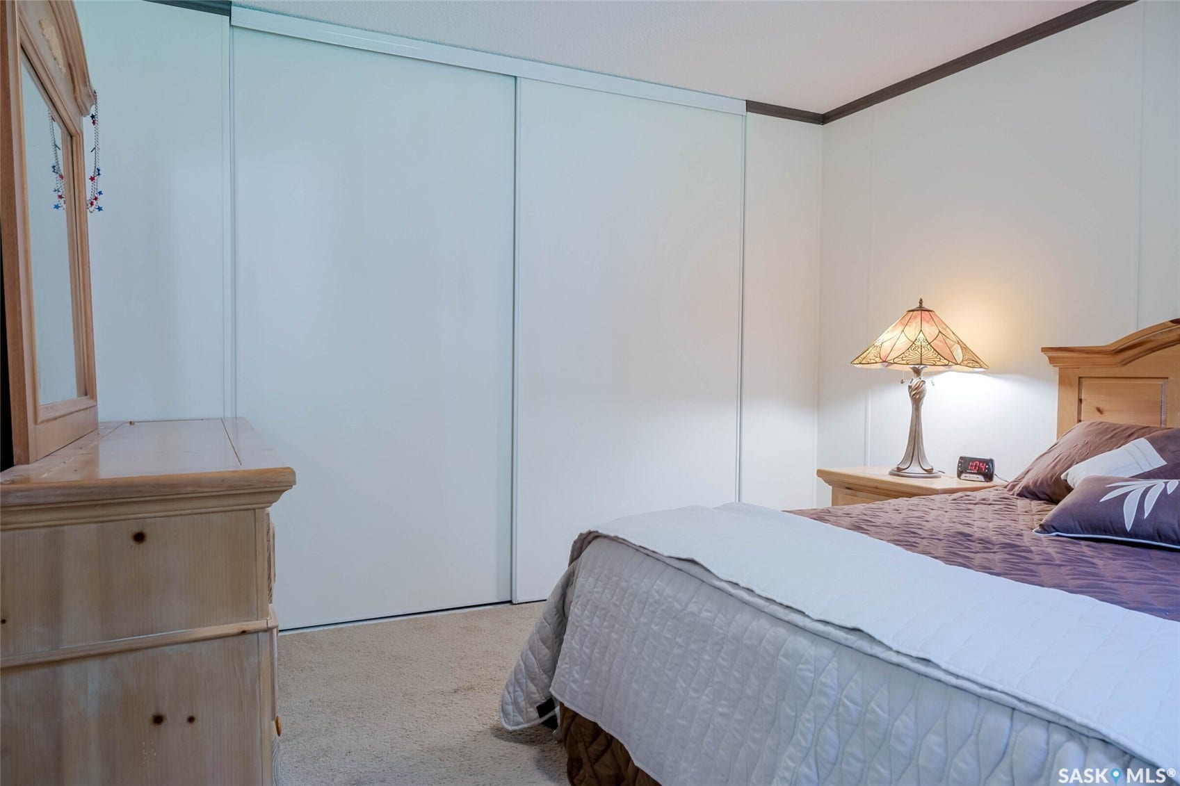 Sliding closet doors, light-toned wall paneling, and wall-to-wall carpeting