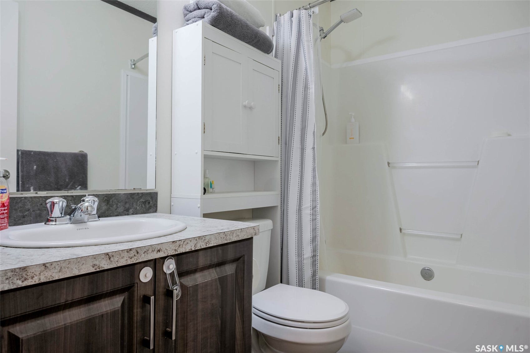 Vanity with a laminate countertop, dark wood-finish cabinetry, and a circular basin sink