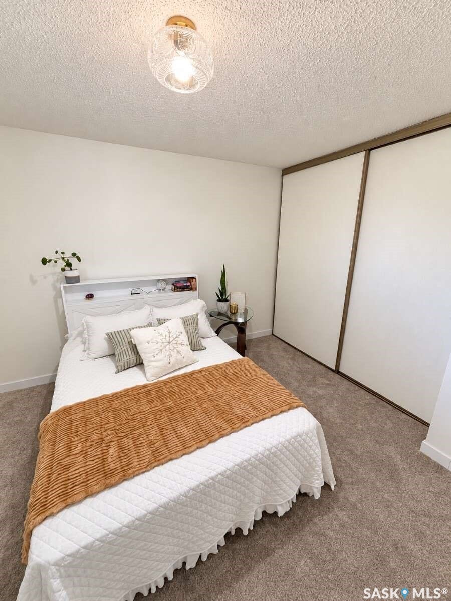 Wall-to-wall carpeting with light-colored walls and a textured ceiling