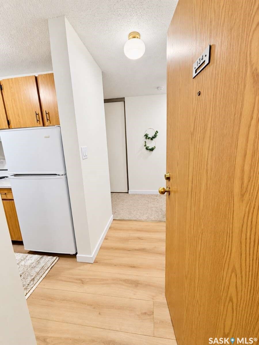 Entryway featuring wood-finish flooring, a flush mount ceiling light, and a solid core door with brass hardware