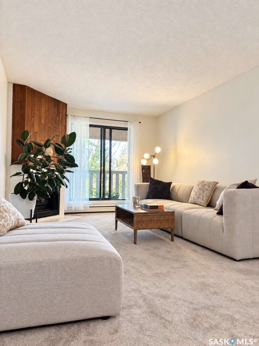 Corner fireplace with wood paneling, sliding glass doors, and light-colored carpeting