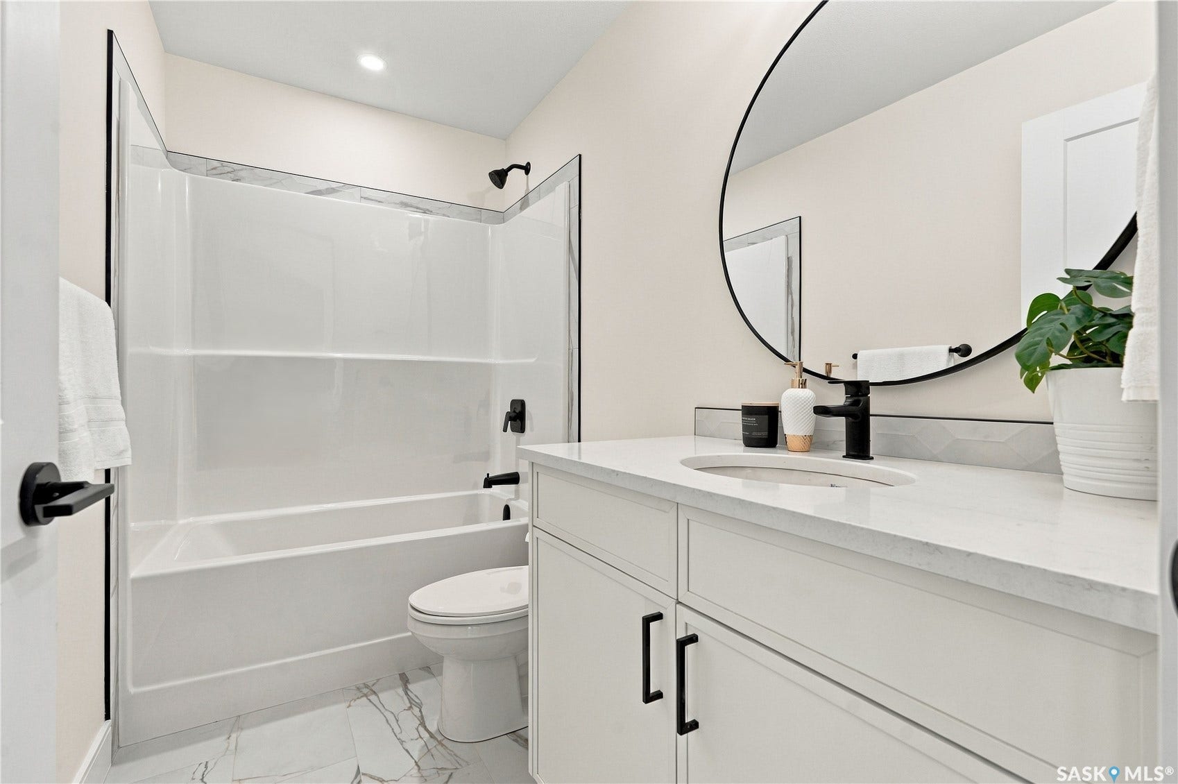 White vanity with a light-colored countertop, undermount sink, and matte black faucet