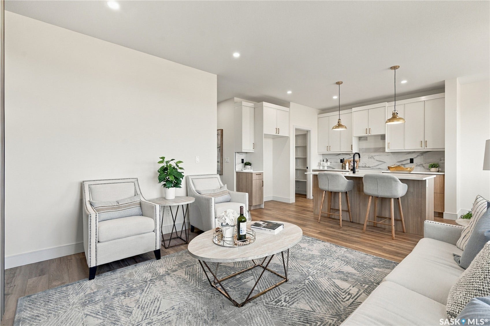 Open-concept living space featuring wood-finish flooring, recessed lighting, and a kitchen with an island, pendant lighting, and a tile backsplash