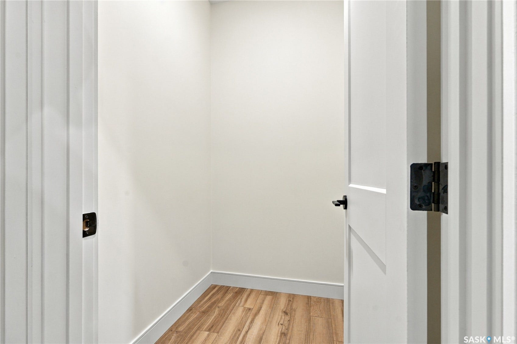 Recessed storage space featuring wood-finish flooring and white walls