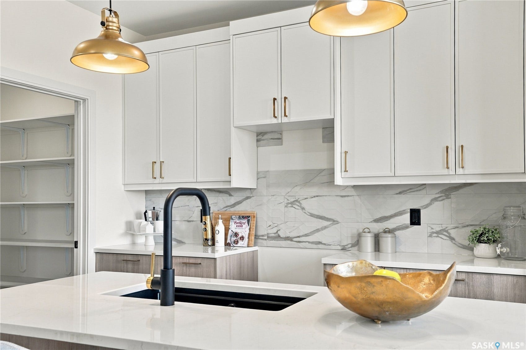 White cabinetry with gold-tone hardware, white quartz countertops, black gooseneck faucet, and a patterned backsplash