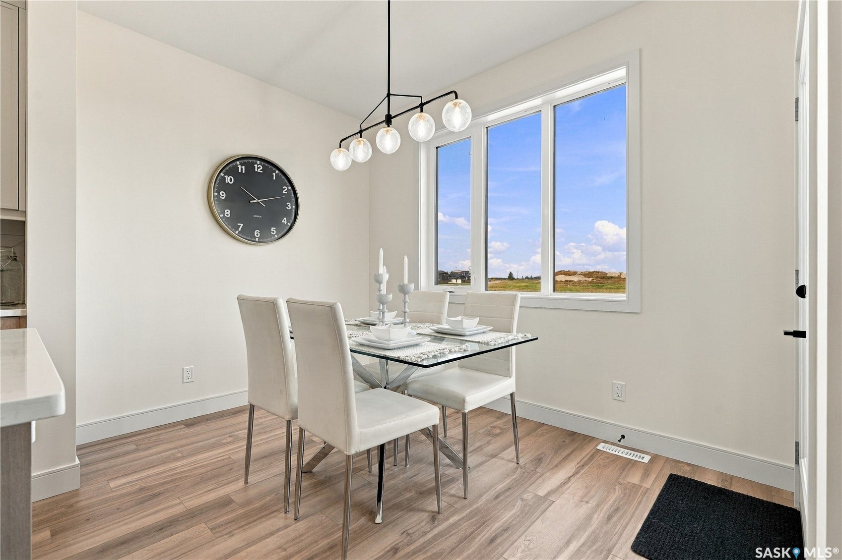 Hardwood-style flooring, white baseboards, and a contemporary chandelier with globe lights