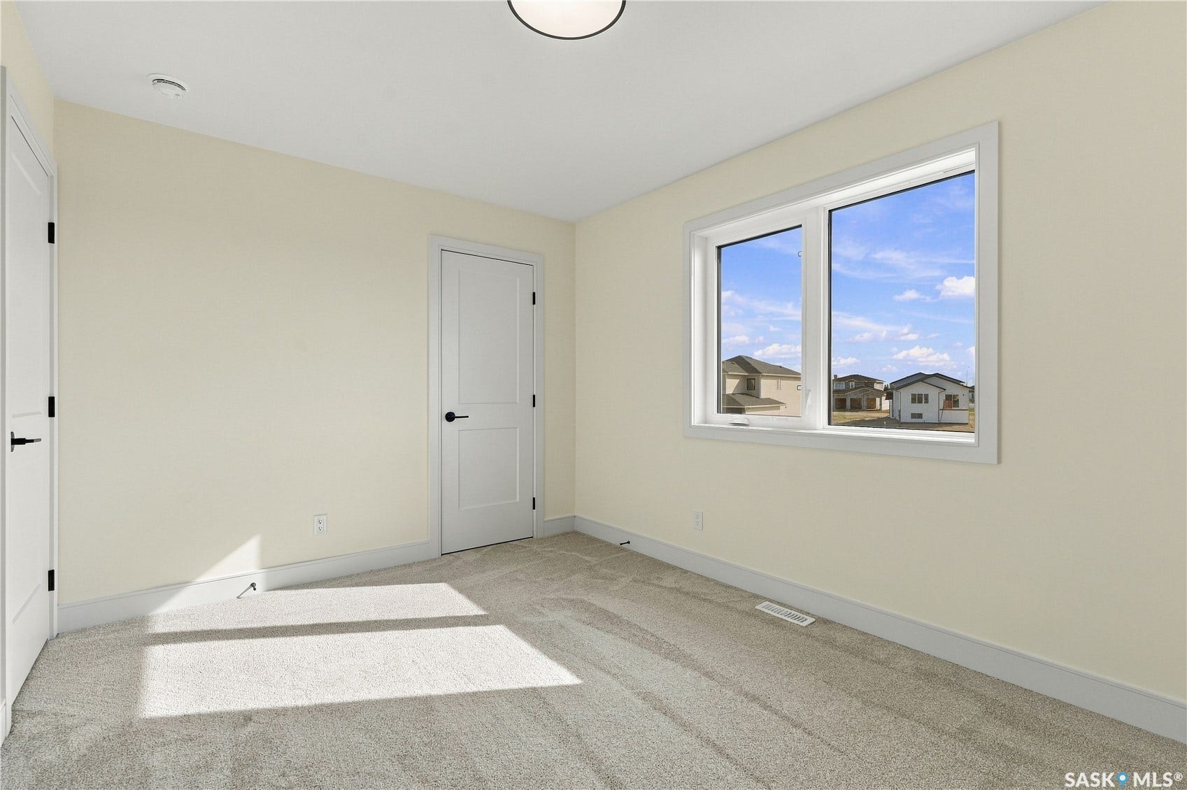 Carpeted flooring, white trim, recessed lighting, and a double-pane window