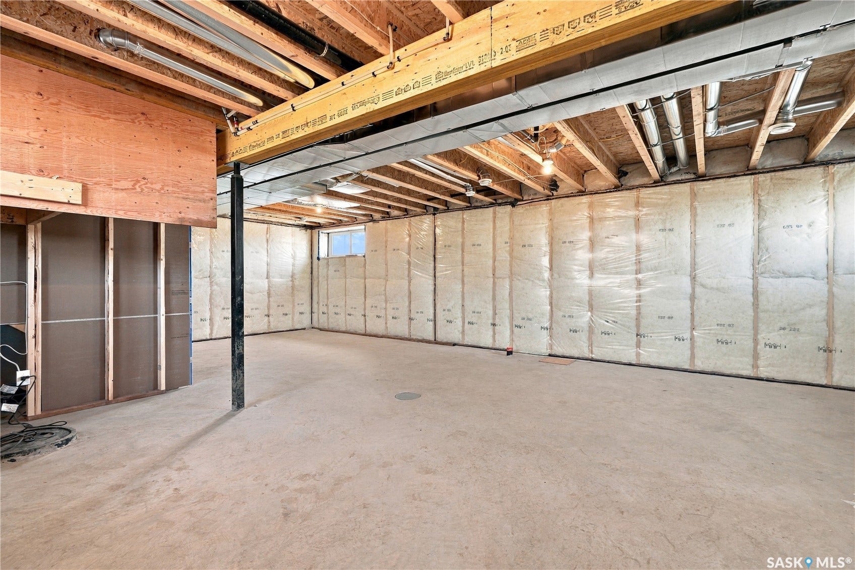 Unfinished lower level with exposed ceiling joists and support beams, insulated perimeter walls, and concrete flooring