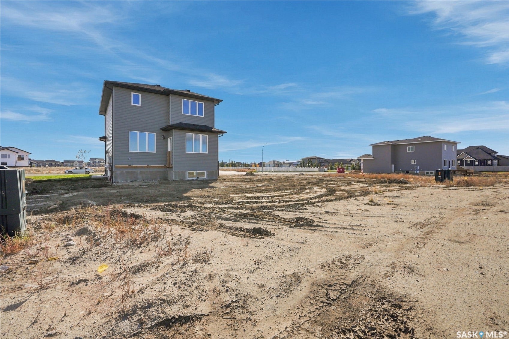 Newly constructed residence featuring a gray exterior, black roof, and multiple large windows
