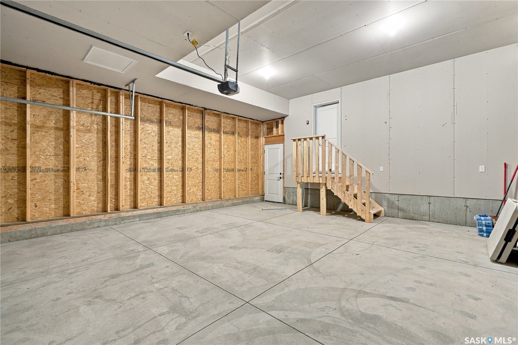 Concrete flooring with panel walls and an exposed wood-frame wall