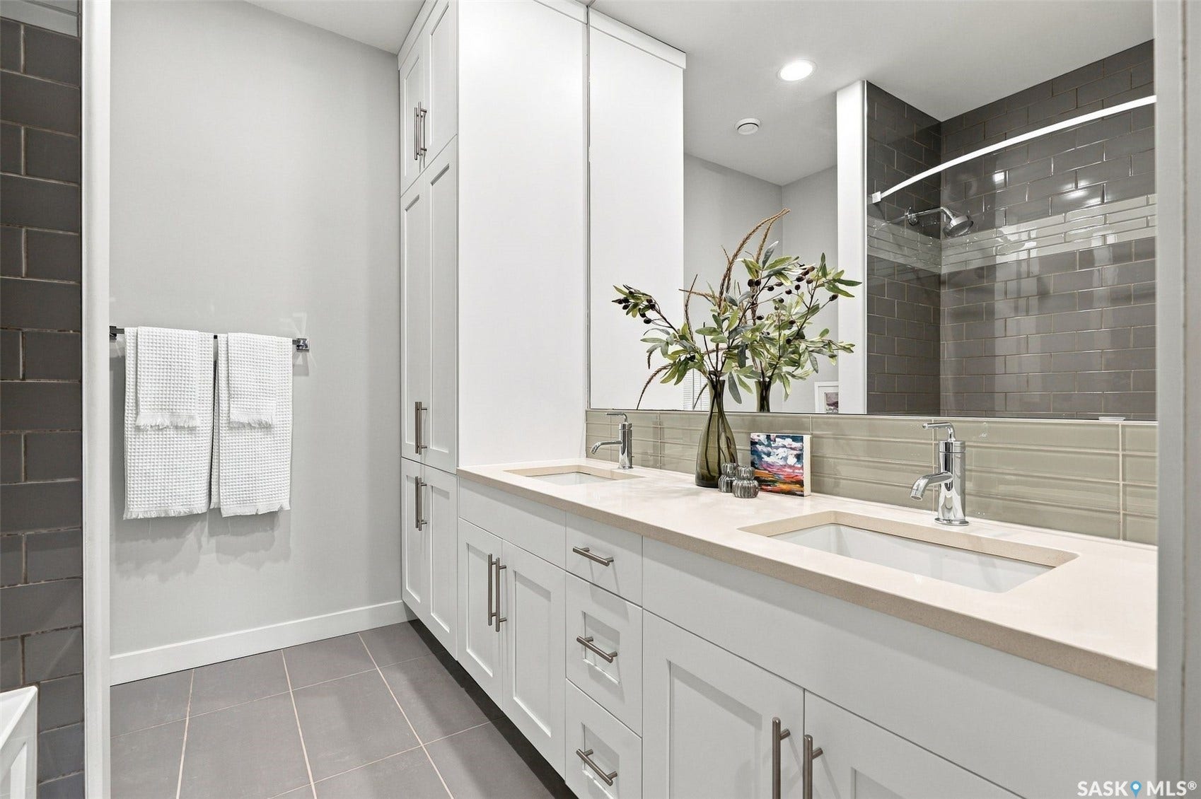 Spa-inspired primary bathroom featuring a floating white vanity with dual rectangular sinks, quartz countertop, and polished chrome fixtures