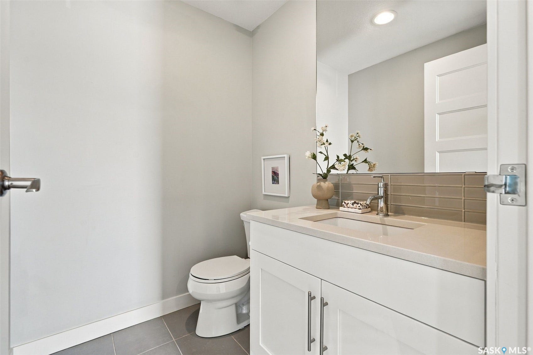 White vanity with ample storage, integrated sink, and light countertop