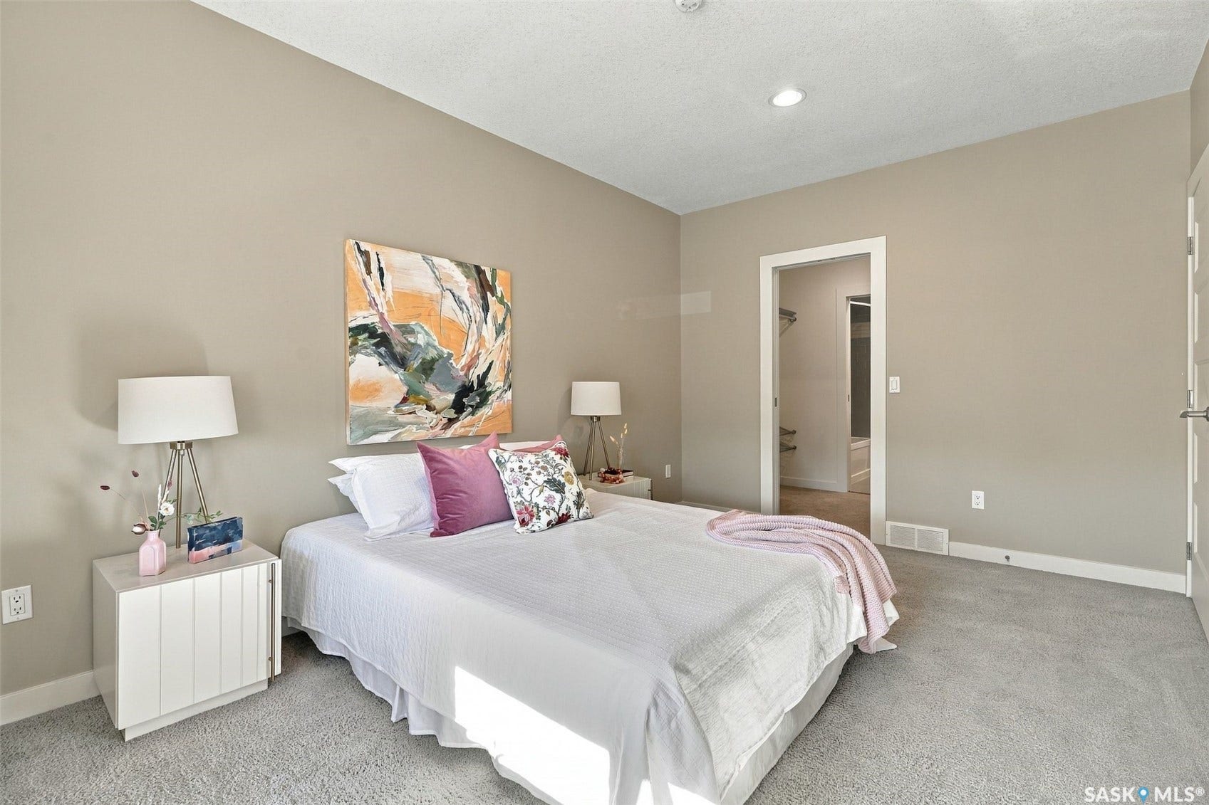 Recessed lighting, neutral wall paint, light-colored carpet flooring, white trim work, and a white interior door