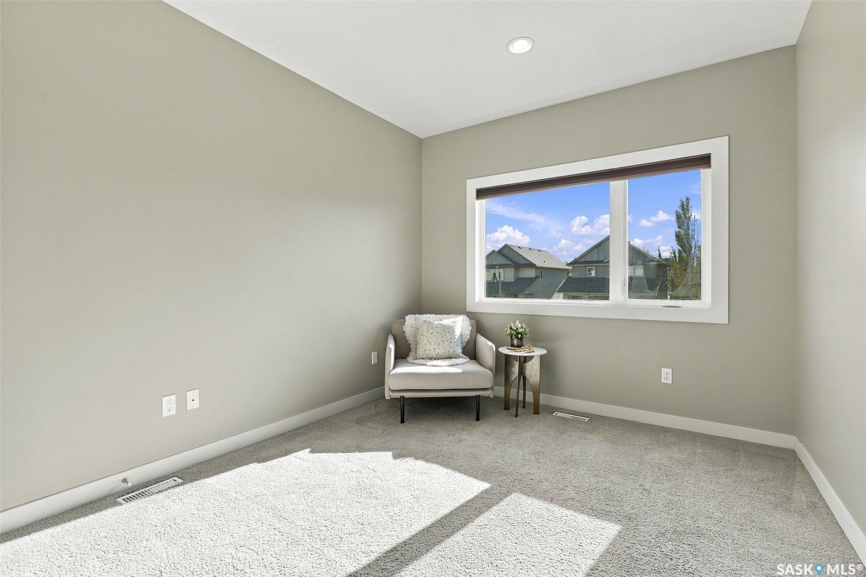 Recessed ceiling lighting, light gray wall paint, white trim, and a large window