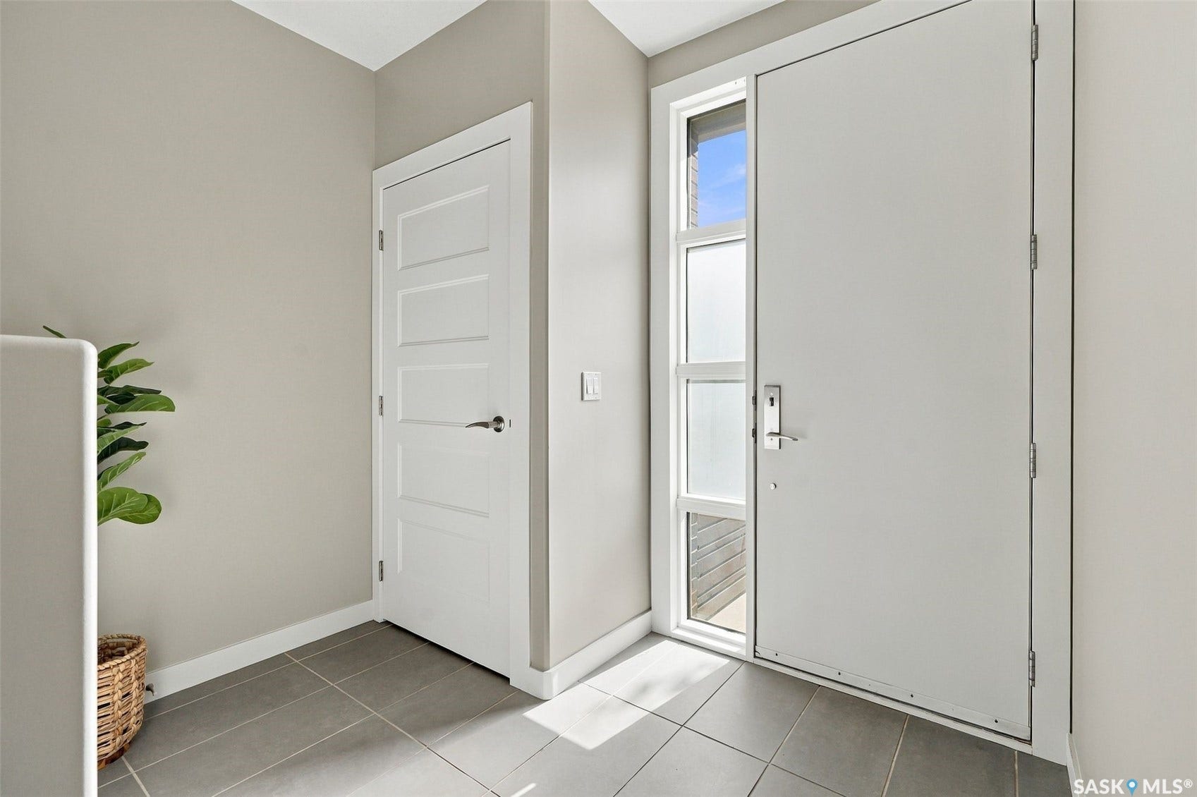 Contemporary entry door with frosted glass sidelight, contrasting with a five-panel interior door