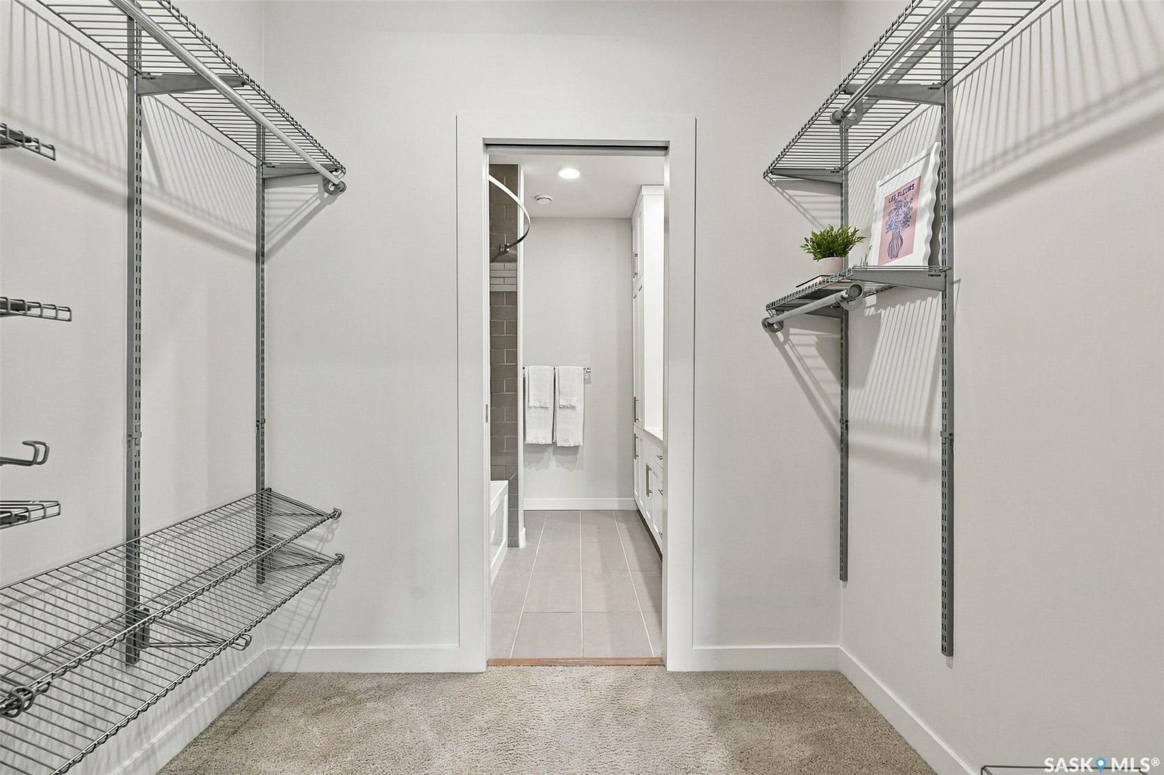 Carpeted walk-in closet with wire shelving and hanging rods