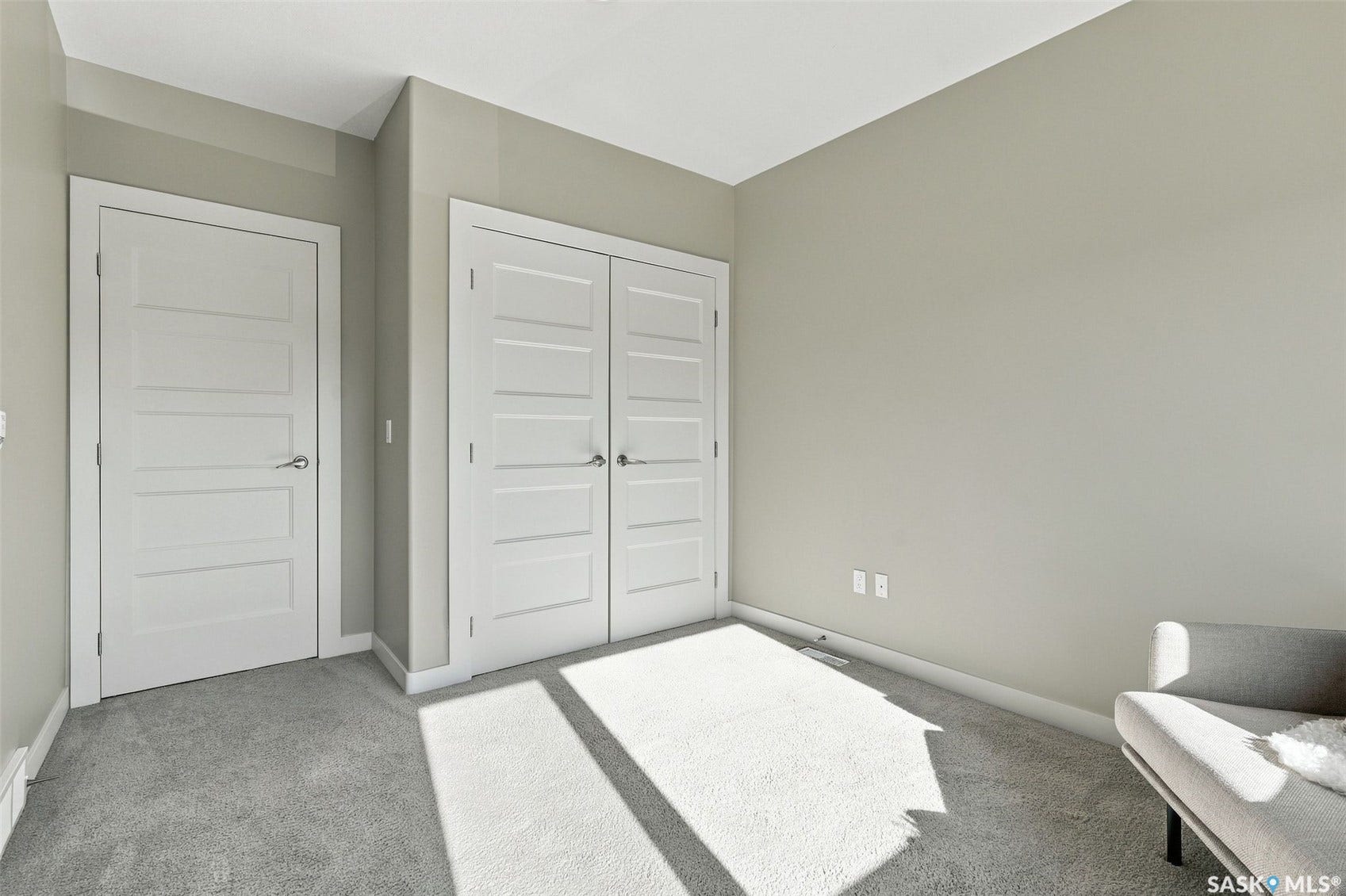 Neutral wall tones, gray carpeting, and multiple panel doors