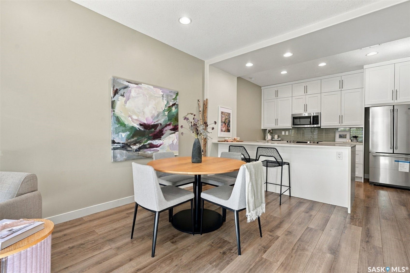 Open-concept kitchen with white cabinetry and stainless steel appliances