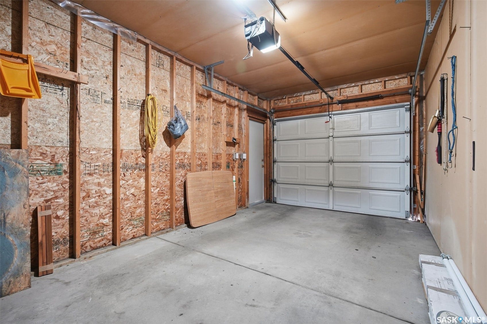 Attached garage featuring a panel garage door, concrete flooring, and an automatic garage door opener