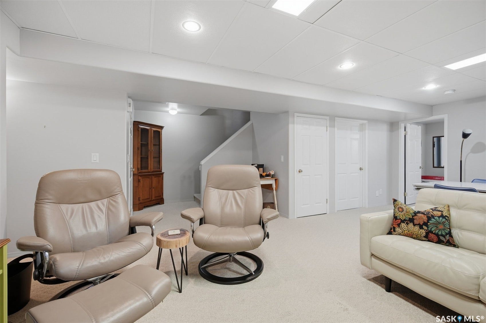 Recessed lighting, light-colored walls, broadloom carpeting, crisp white trim, and white paneled doors