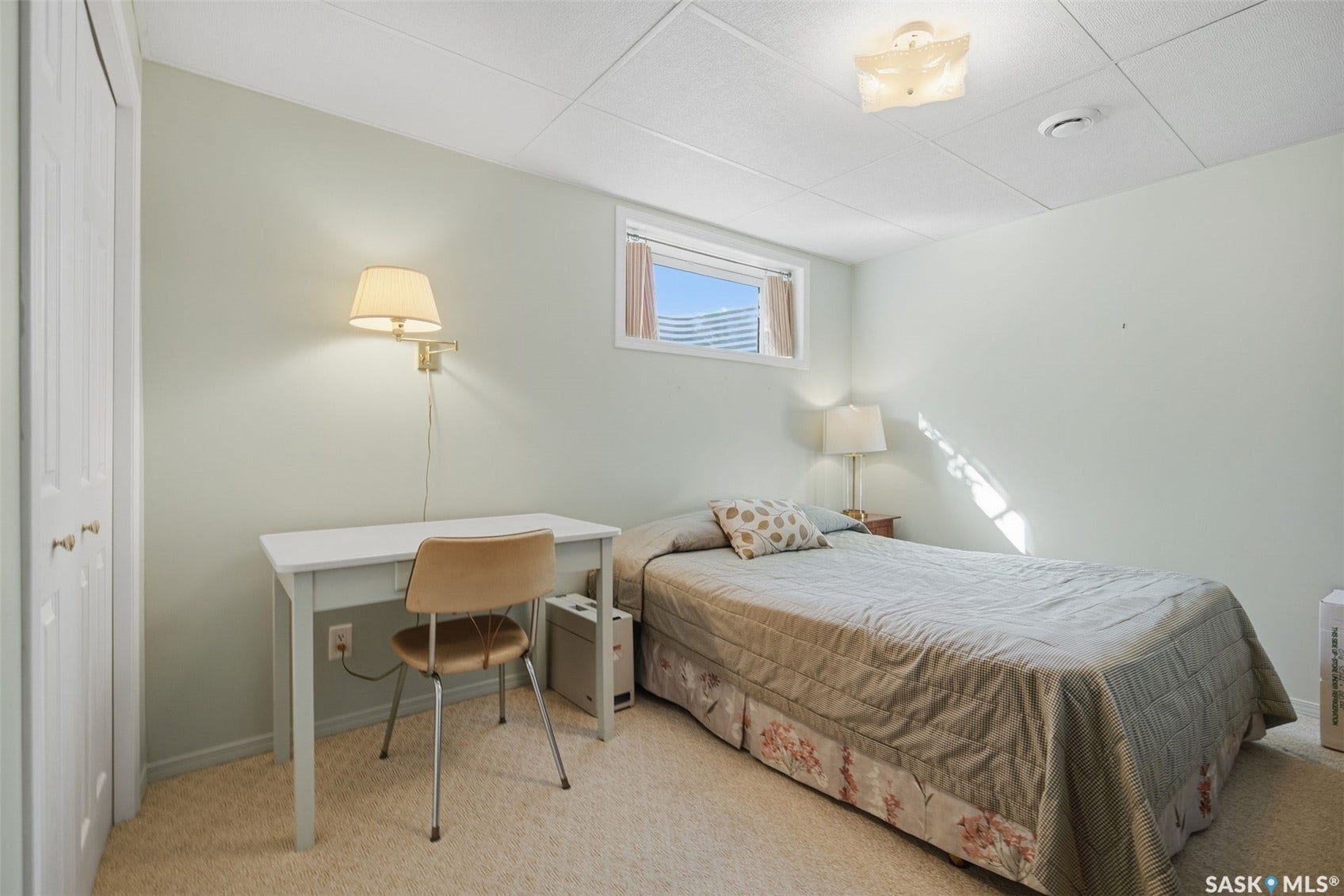 Carpeted flooring, drop ceiling, and a single window