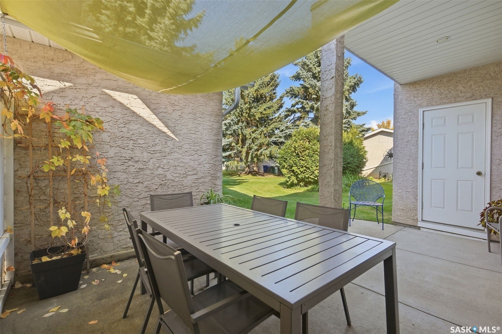 Covered patio with textured exterior wall, concrete flooring, and an exterior door