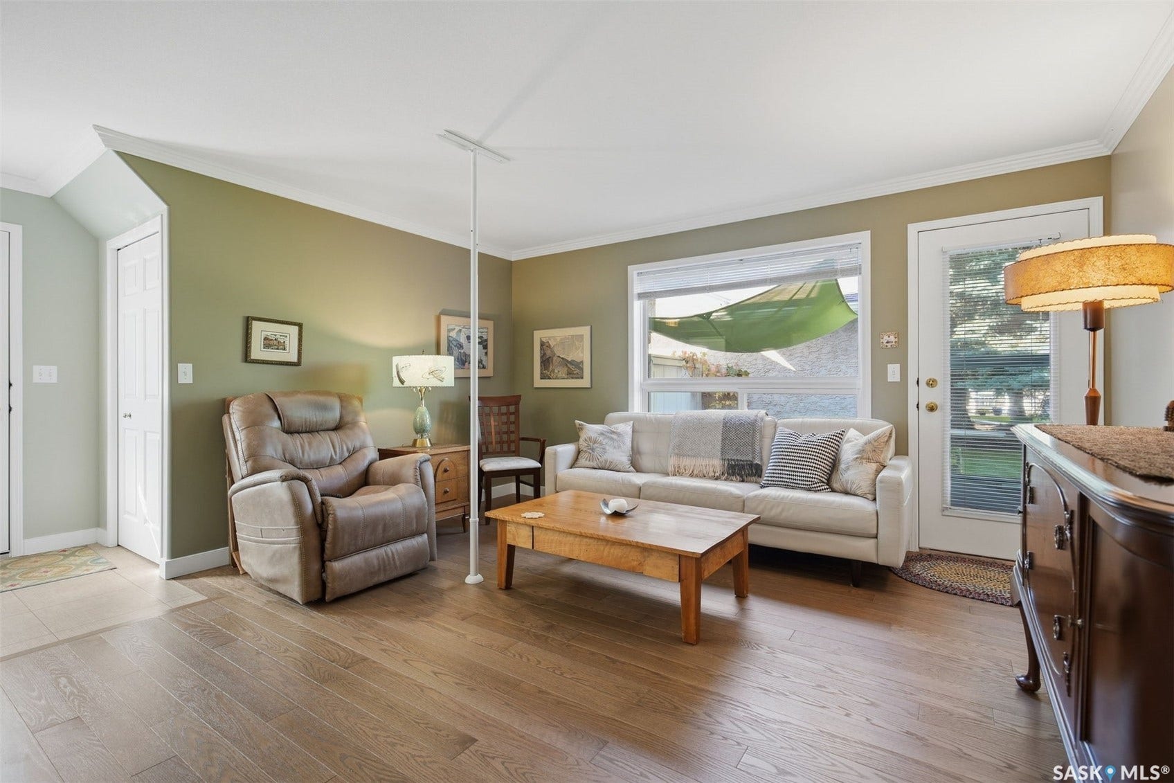 Wood-finish flooring, white trim, and a large window with a glass-paned door