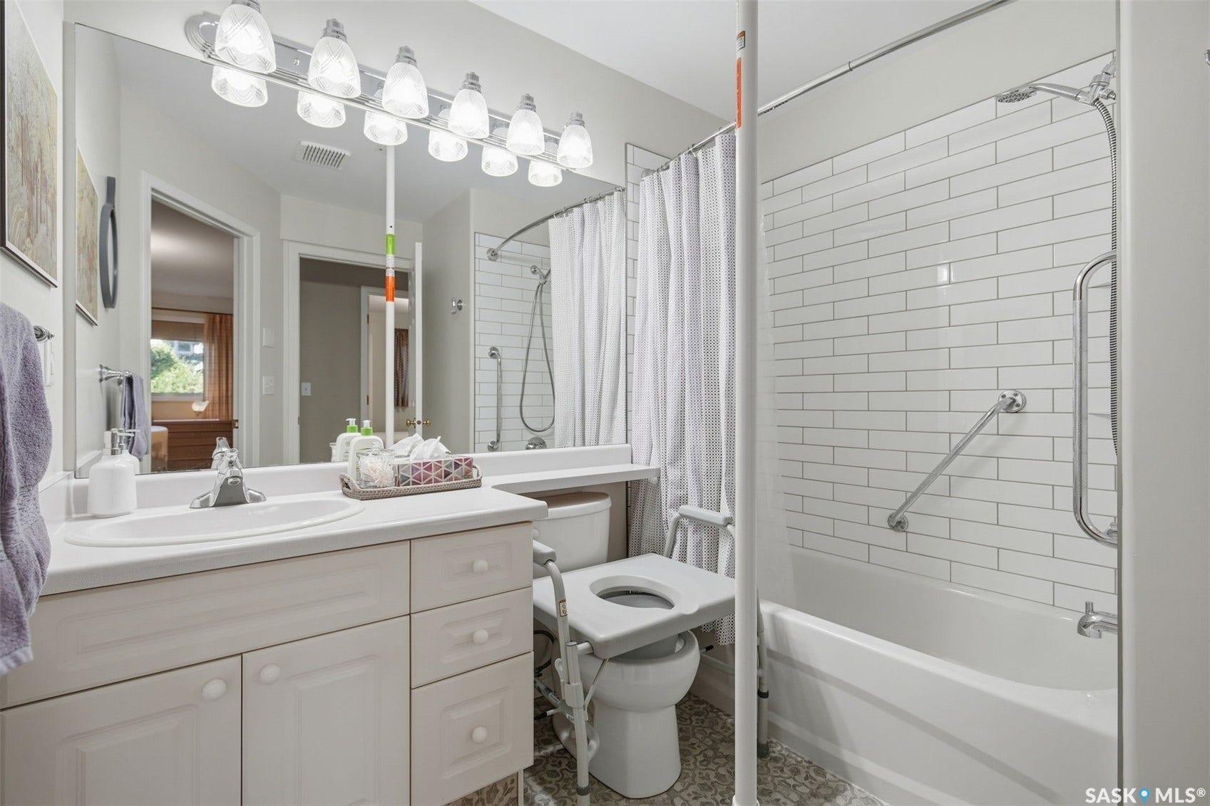 White vanity with integrated sink, chrome faucet, and storage cabinetry
