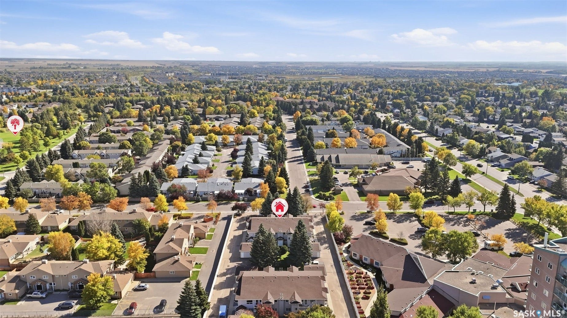 Residential neighborhood with tree-lined streets, a mix of single-family homes and multi-unit buildings, and visible commercial structures