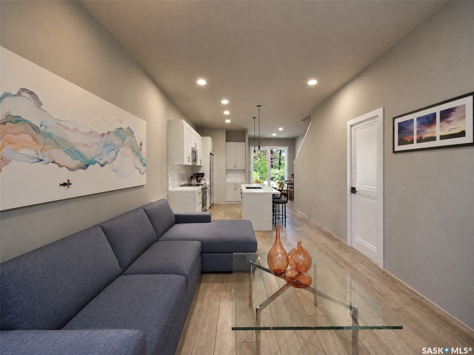 Recessed lighting, wood-finish flooring, white kitchen cabinetry, stainless steel appliances, and a kitchen island with pendant lighting