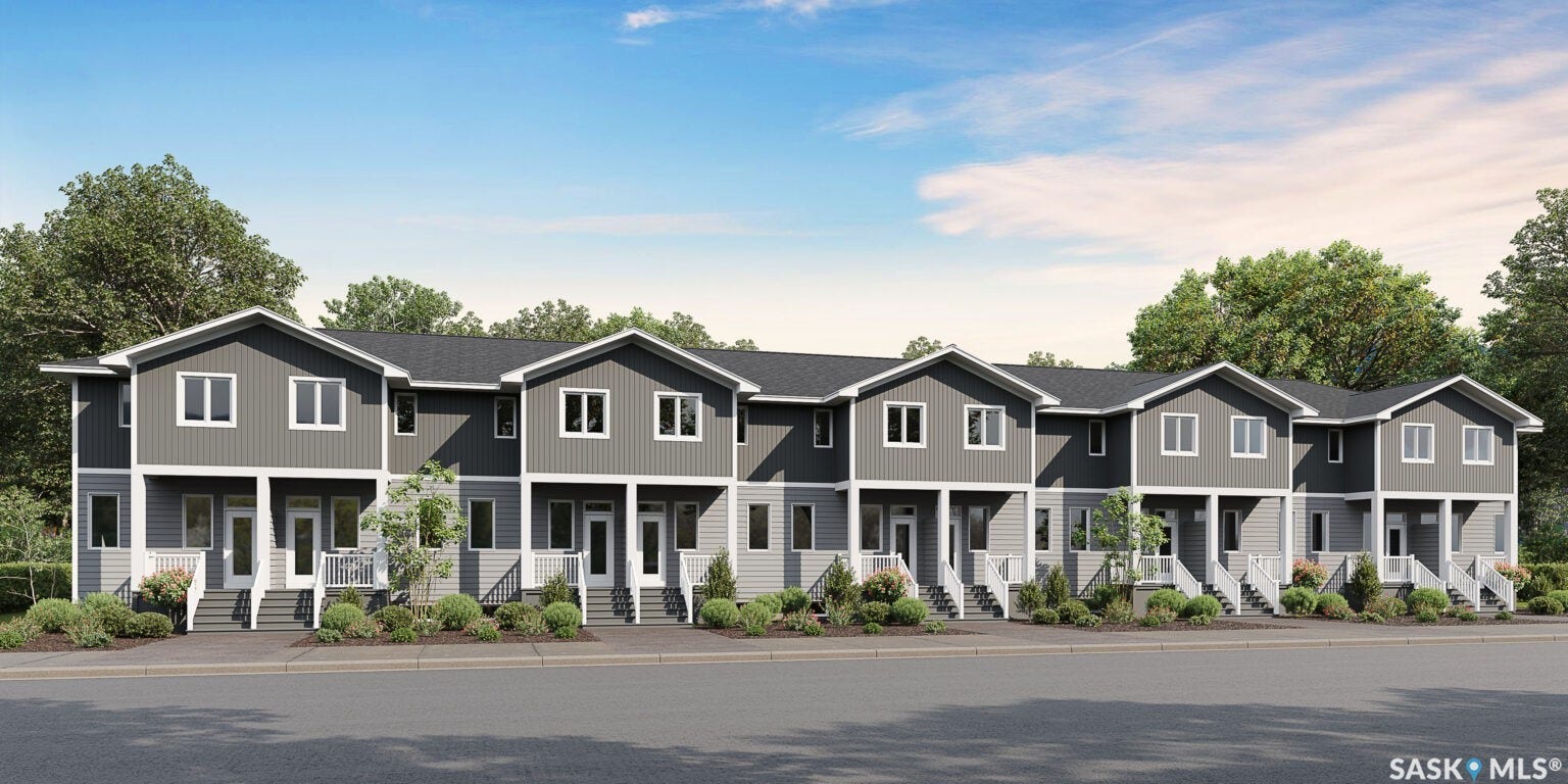 Contemporary townhomes featuring gray siding and white trim, individual covered entries, and neatly maintained landscaping