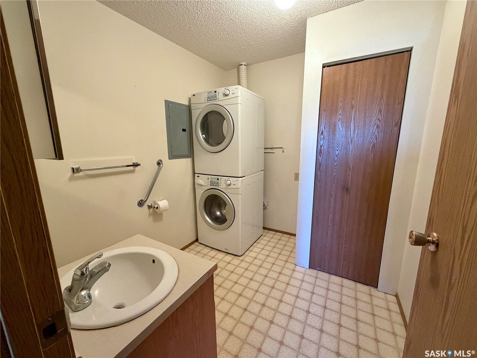 305 1st Street W, #301, Rosetown SK S0L 2V0 Built-in vanity with an integrated sink, chrome faucet, and wood-finish cabinetry