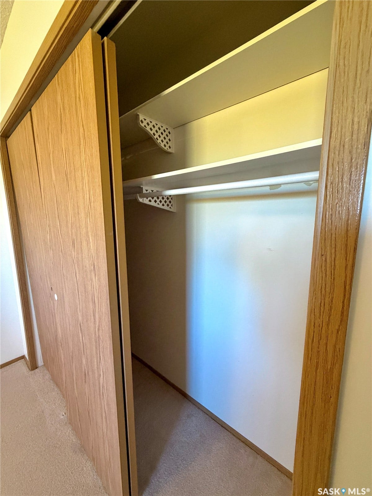 305 1st Street W, #301, Rosetown SK S0L 2V0 Sliding closet doors with wood-finish panels, featuring a built-in shelf and clothing rod