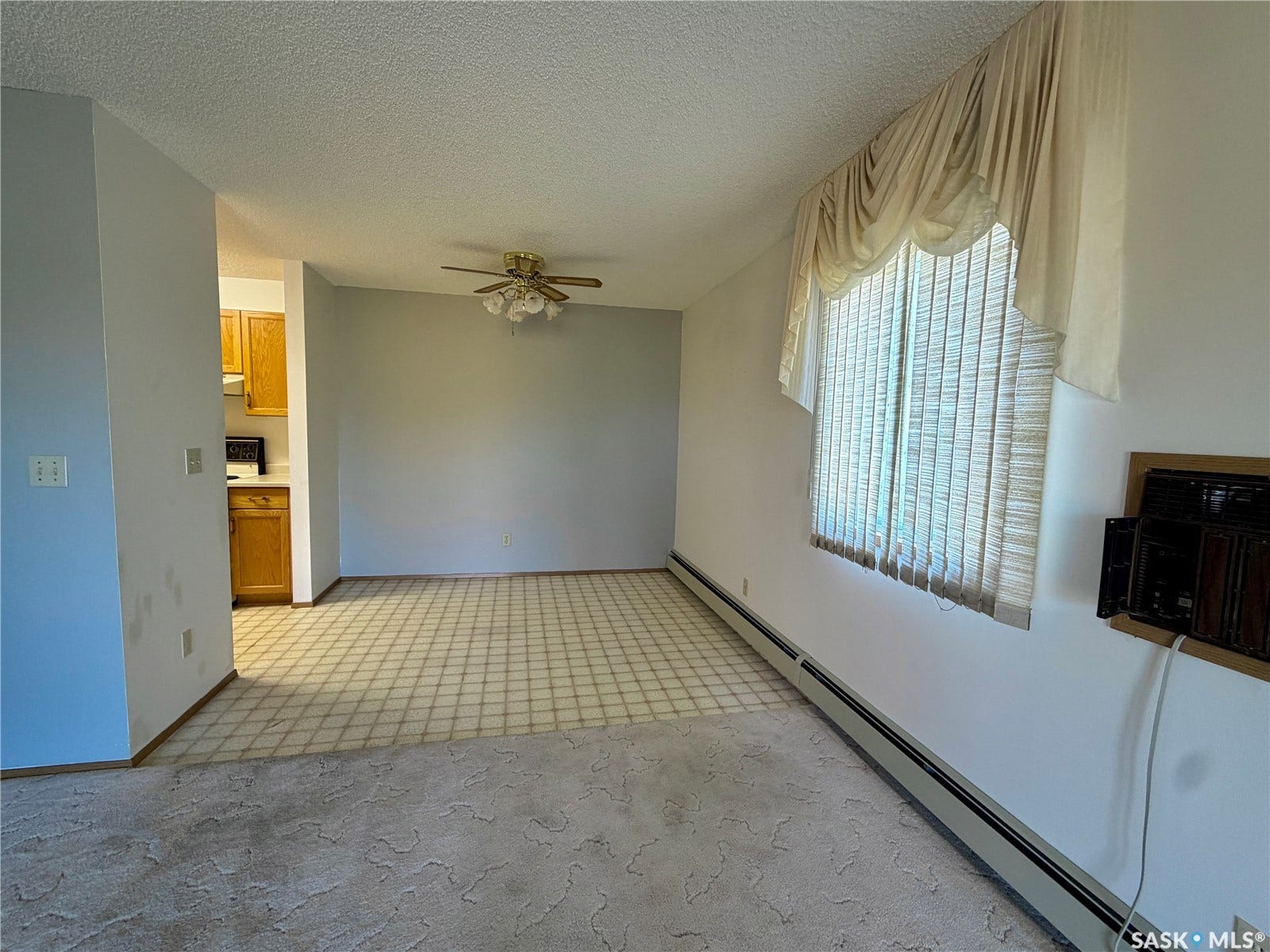 305 1st Street W, #301, Rosetown SK S0L 2V0 Recessed ceiling fan, textured ceiling, baseboard heating, window with vertical blinds, and wood-finish cabinetry