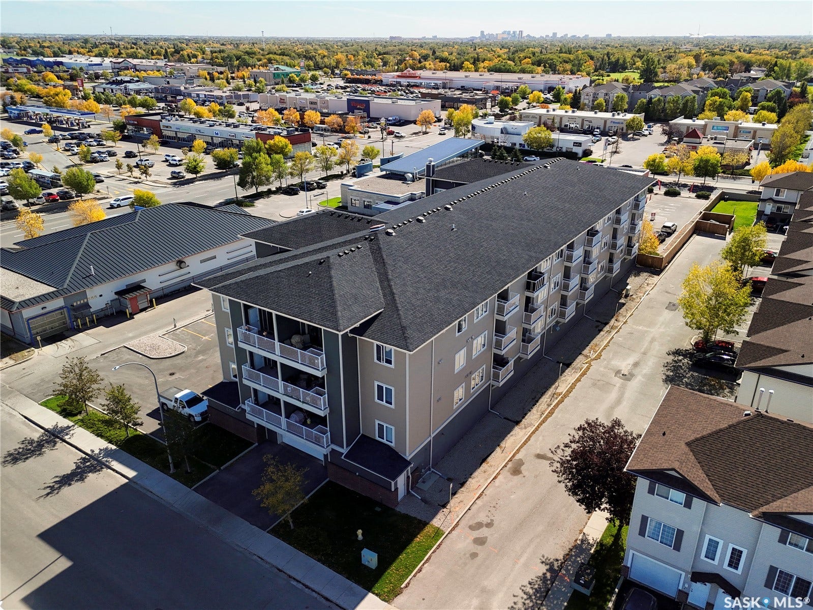 Multi-story building with balconies and dark shingle roofing