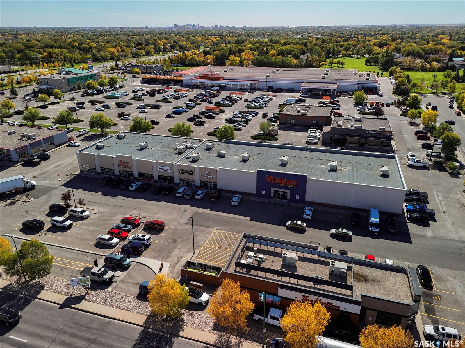Retail building with multiple storefronts and an expansive paved parking lot