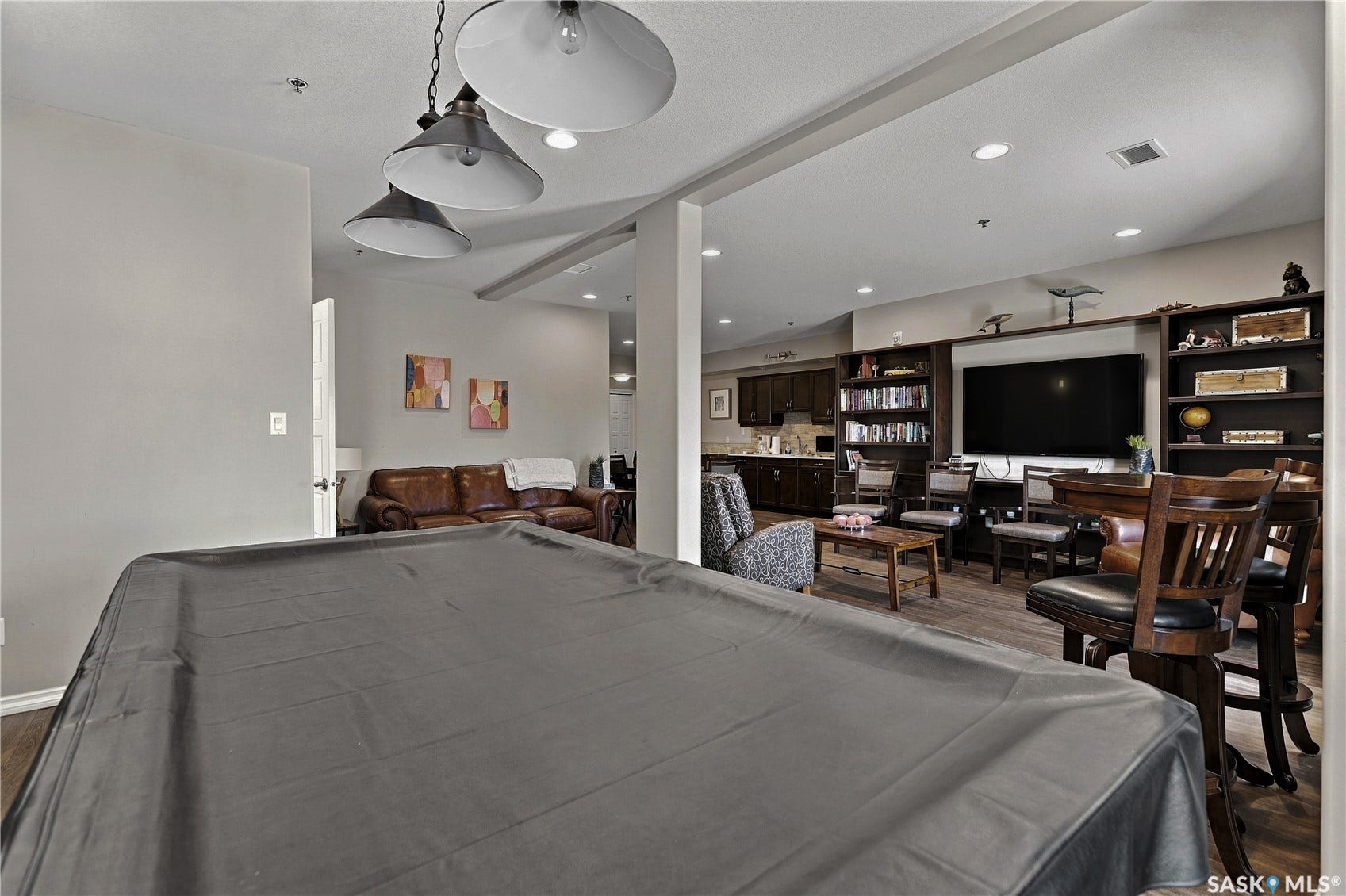 Recessed lighting and industrial-style pendant fixtures illuminate the space