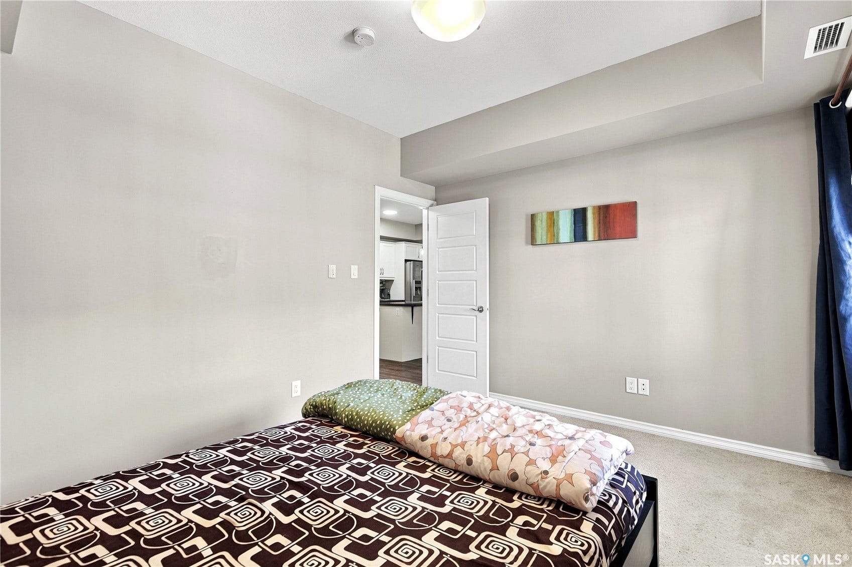 Neutral wall paint, carpeted flooring, and a paneled door