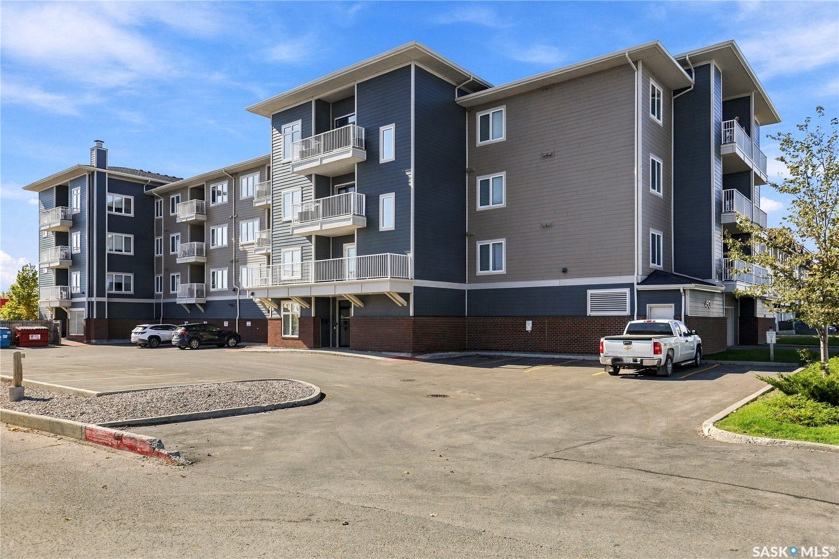 Multi-story residential building with a brick base and multi-toned siding