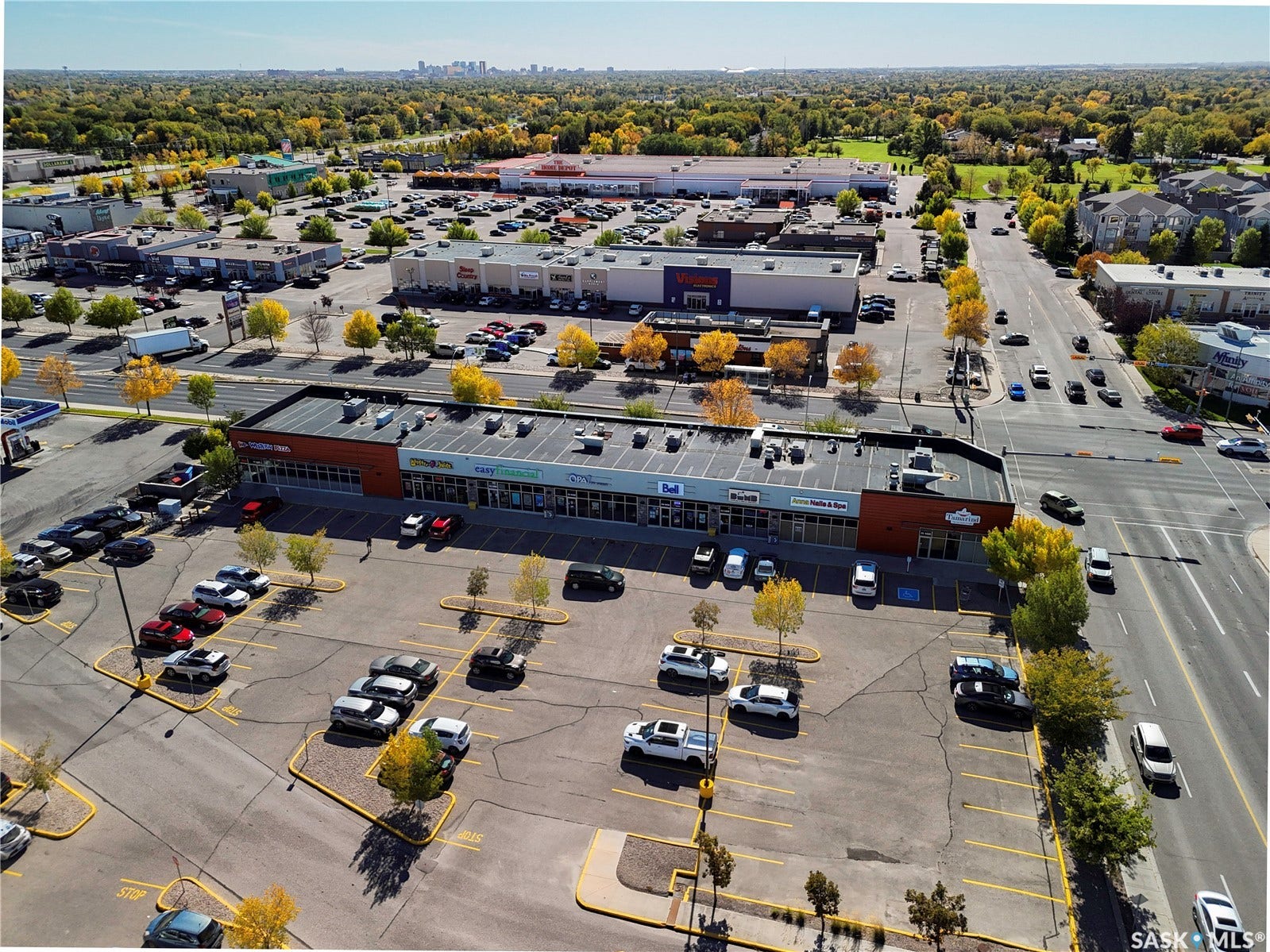 Commercial building featuring multiple retail storefronts, extensive surface parking, and prominent street frontage