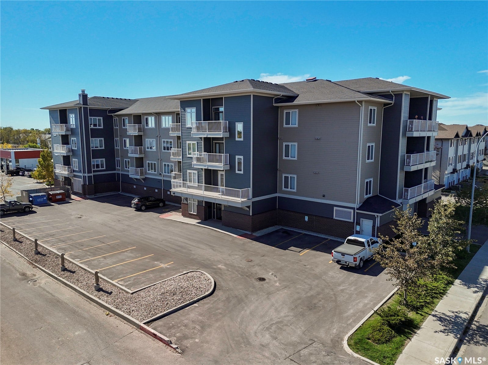 Multistory building with contemporary siding, private balconies, and an onsite parking area